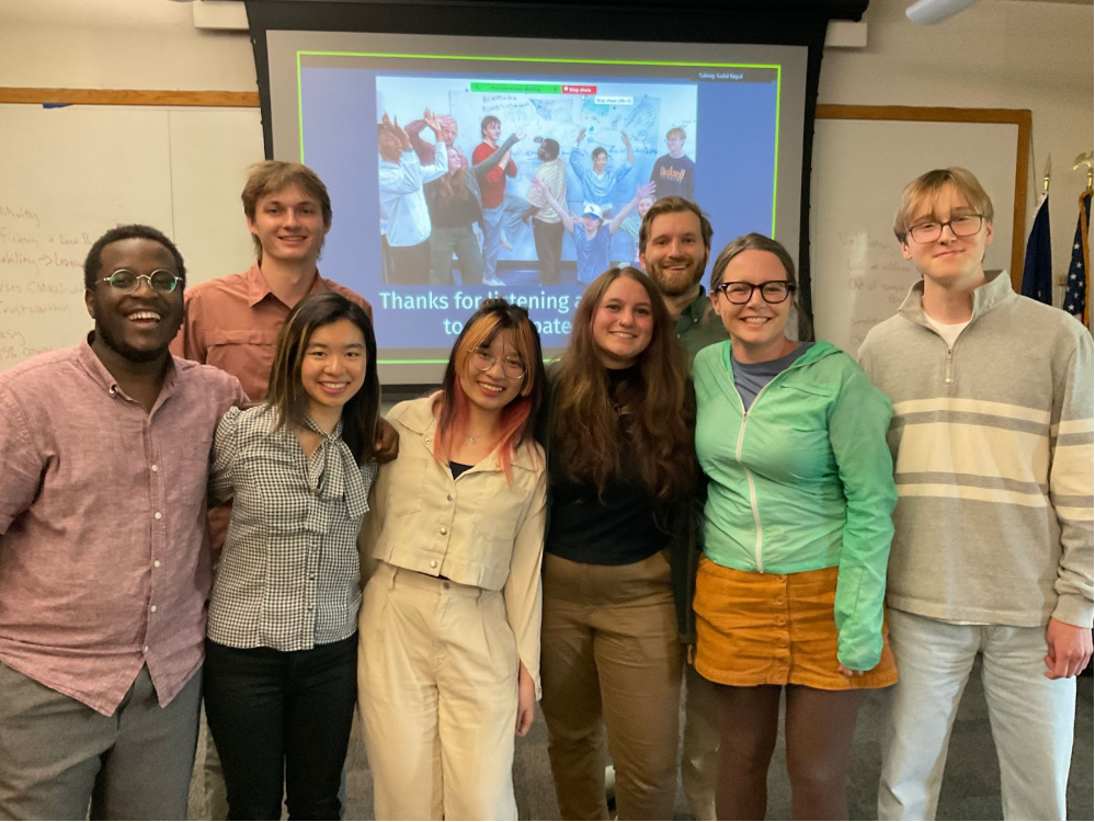 A group photo of eight of the students and mentors who worked on the Bucknell Undergraduate Forestry Data Science Research Program, standing in front of presentation slides.
