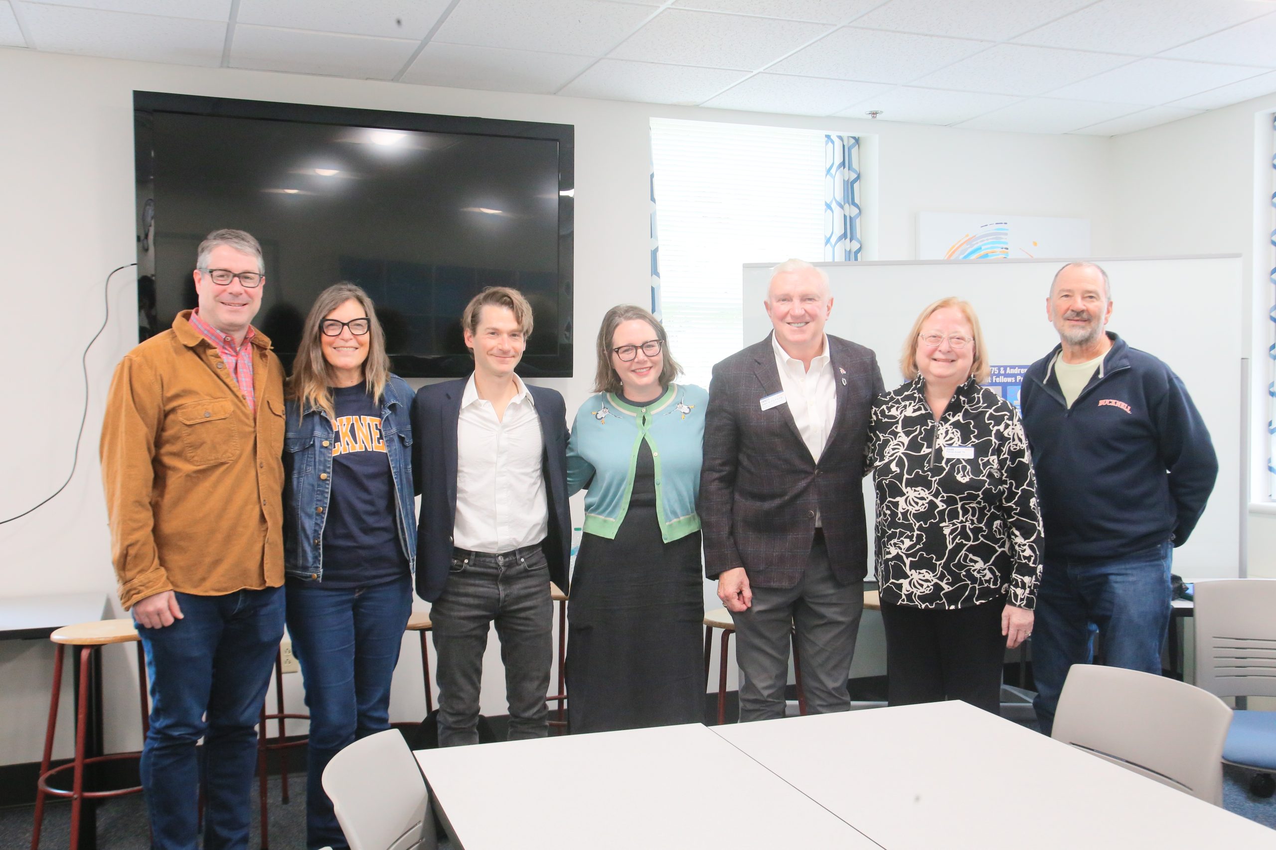 Celine and JoAnn standing under a lighted tent chatting.