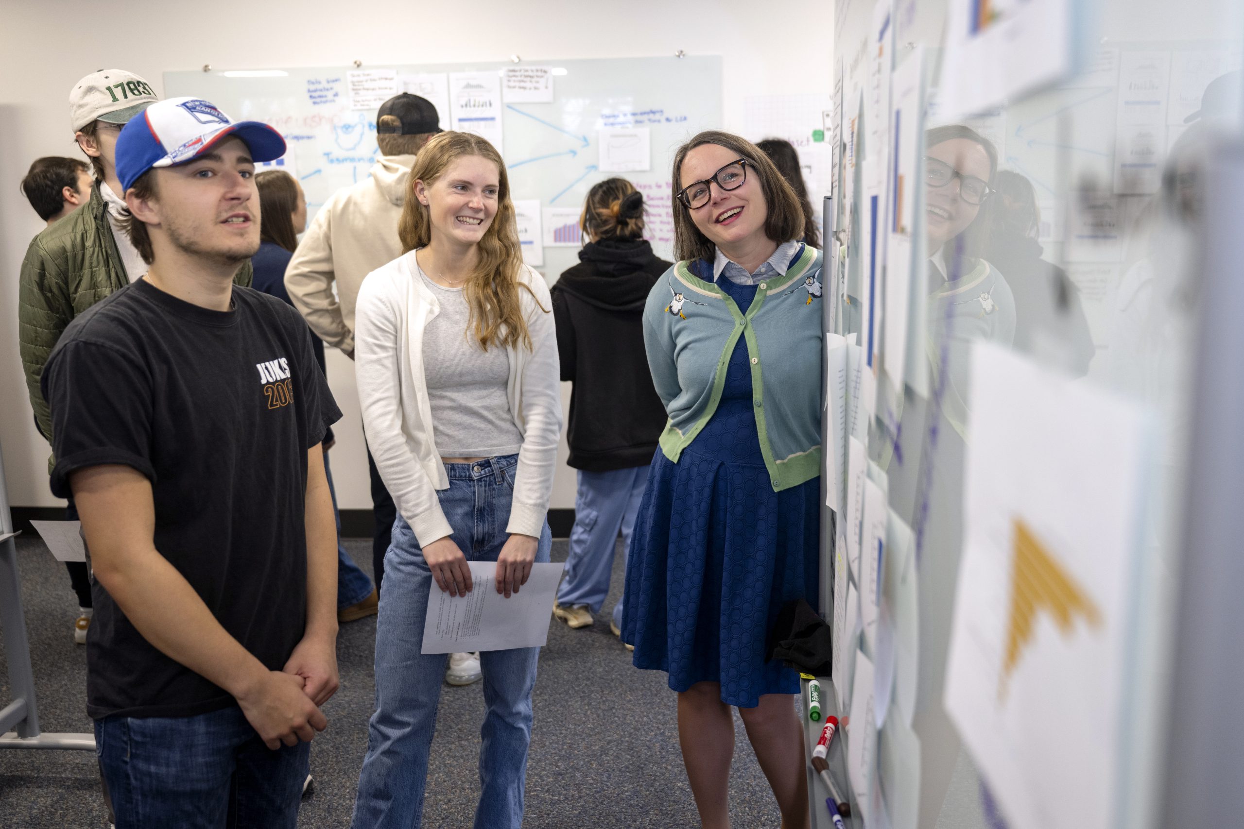 Max Wilson, Joe Wilck, and Sam Gutekunst walking across the Bucknell football field. Max is holding a football.