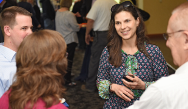 Several people standing in a small group chatting.
